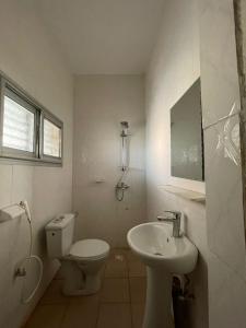 巴马科Résidence Le TOUNKARANKE ACI 2000的白色的浴室设有卫生间和水槽。