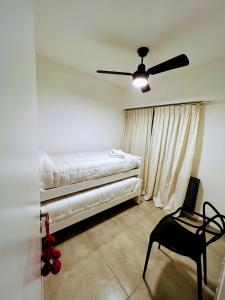 圣罗莎Departamento Catedral的一间卧室配有一张床、一把椅子和吊扇
