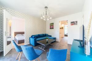 布隆Appartement spacieux 8 pers avec balcon Bron的客厅配有蓝色的沙发和蓝色的椅子