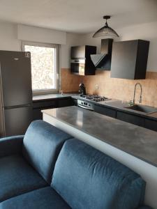 卡瓦永appartement 4 couchages renovés entièrement的厨房在柜台前设有蓝色沙发