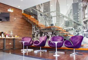 利马阿酷酒店的大堂设有紫色椅子和楼梯