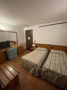 科尔蒙斯Villa Felcaro - Relais, Lodge & Restaurant的酒店客房配有两张床和一张书桌