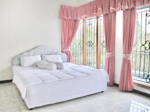 班顿甘Villa Hijau Bandungan的窗户客房内的一张白色床