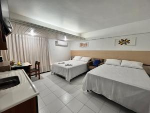 若昂佩索阿Flat Tambaú的酒店客房设有两张床和盥洗盆
