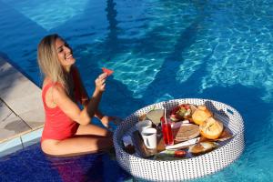 BalianBali Hai Island Resort的吃游泳池旁食物的女人