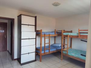 纳塔尔Hostel Atairú的带三张双层床和镜子的客房