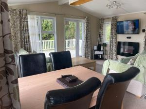 纽顿3 Bedroom Lodge - Willows 24, Trecco Bay的客厅配有木桌和椅子
