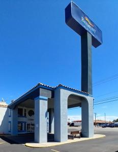 金曼Baymont by Wyndham Kingman的前面有一个蓝色标志的加油站