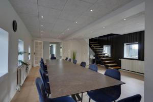 宝可波9 Rooms Amazing Sommerhouse的一间会议室,配有长桌子和蓝色椅子