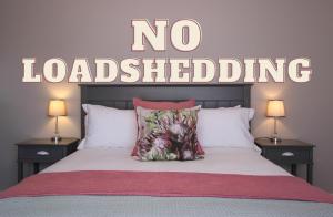 西萨默塞特Brookshill - Protea suite的卧室配有一张壁上没有装载标志的床
