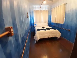 德尔菲诺波利斯Casa Topázio no Container dos Cristais的蓝色客房中一间带床的卧室
