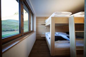 丰塔内拉Berg Aparts - Top 6 - Faschina - mit Sauna & 2 Bädern的小房间设有两张双层床和窗户