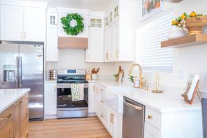 卡纳布Rustic Gold Retreat的厨房配有白色橱柜和不锈钢冰箱