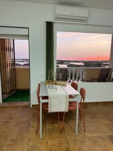 奇克拉纳－德拉弗龙特拉Apartamento puestas de sol的一间配备有白色桌椅的用餐室