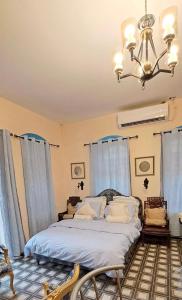 耶路撒冷La Provençale的一间卧室配有一张床和一个吊灯