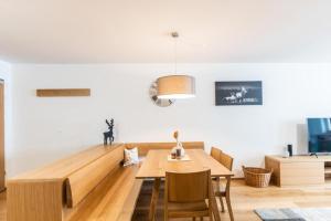 丰塔内拉Faschina Apartment - Top 4的一间带木桌和椅子的用餐室
