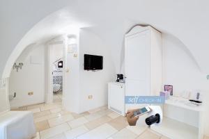 卡洛维诺Dimora Dell'Osanna Raro Villas Smart Rooms Collection的墙壁上配有电视的白色浴室