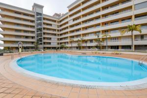 丰沙尔By the Sea II - calmo com piscina e vista mar.的大型公寓大楼前的大型游泳池