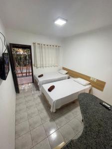 蓬塔波朗HOTEL MARAMBAIA的酒店客房,设有两张床和镜子