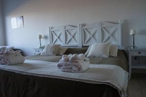 皮拉米德斯港瑞斯厅加斯马尔酒店的一间卧室配有一张大床和毛巾