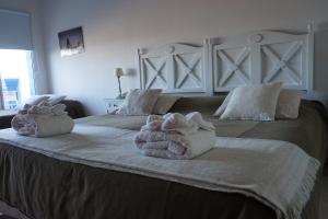 皮拉米德斯港瑞斯厅加斯马尔酒店的一间卧室,在大床上配有2条毛巾