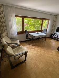 梅尔斯堡Ferienwohnung Urban - AHORN -- Meersburg的客厅配有桌椅和窗户。