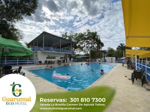 卡门阿皮卡拉Eco Hotel Guarumal的度假村的游泳池,里面的人