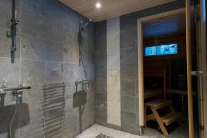 普哈圣山Log-house at Pyhätunturi ski resort.的一间带步入式淋浴间和长凳的浴室