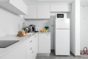 埃拉特דירה משפחתית מפנקת 50 מטר מהים - By Edom的厨房配有白色橱柜和白色冰箱。
