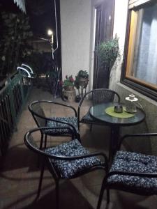 莱斯科瓦茨Fina Apartment的庭院设有三把椅子、一张桌子和一扇窗户。