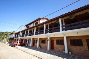 伯迪亚哥Pousada Acqua Azul的前面有一辆红色汽车的建筑