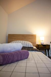 戈斯皮奇Timeless的一间卧室配有一张带紫色毛巾的床