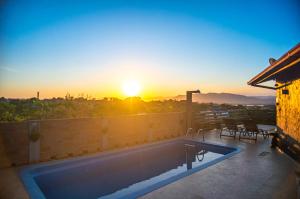 因比图巴Bangalôs do Rosa-Praia do Rosa的一座享有日落美景的房屋屋顶上的游泳池