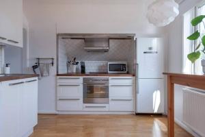 哥德堡WHITE & BRIGHT Room in a shared apartment的厨房配有白色家电和白色冰箱