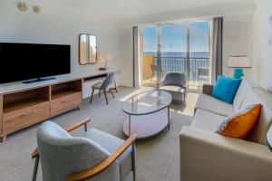 劳德代尔堡大西洋Spa酒店的客厅配有电视、沙发和椅子
