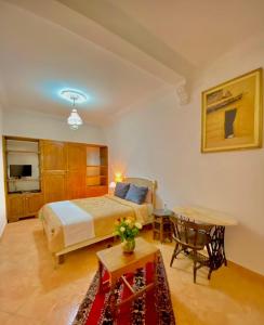 马拉喀什Dar Baddi的酒店客房配有一张床铺和一张桌子。