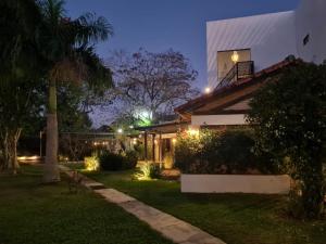 圣贝纳迪诺La Pinta Hotel Boutique的棕榈树和灯火的夜晚房屋
