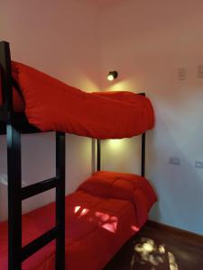 埃斯克尔Complejo turístico Nahuel pan的一间卧室配有两张双层床,铺有红色床单
