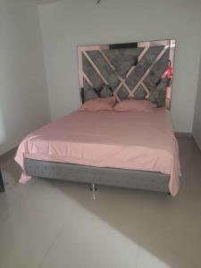 库库塔CASA AMOBLADA EN CONJUNTO CERRADO的一张带粉色床单和木制床头板的床