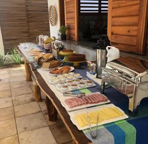 Amontadaicaraizinho villa soleil的一张长桌,上面有不同种类的食物