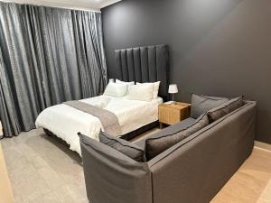 曼齐尼Canal View Estate & Resort的一间卧室配有一张床和一张沙发