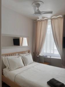 直布罗陀Engineer Lane House的一间卧室配有一张带吊扇和窗户的床。