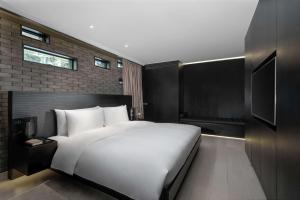 成都博舍的卧室配有一张白色大床和电视。
