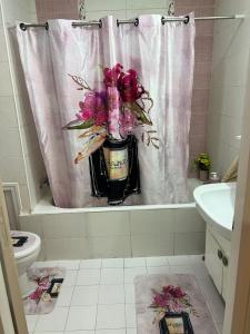 突尼斯Appartement L'aouina cité wahat的浴室设有浴缸,配有花瓶