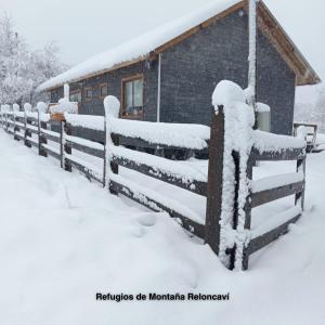 拉斯特朗卡斯Refugios de Montaña Reloncaví - Ruka Lee I的建筑物旁的雪覆盖的栅栏