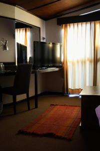 卡哈马卡Hotel Pilancones的客厅配有书桌、电视和椅子