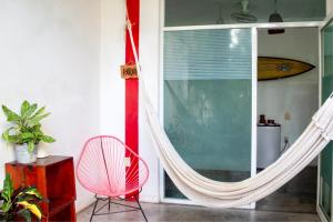 埃斯孔迪多港Casa Daikiri的客房设有吊床、椅子和窗户。