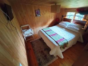 梅利佩乌科Hostal Turismo Allipen的小木屋内一间卧室,配有一张床