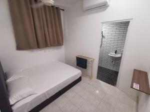 居林Kulim Mini HomeStay的一间卧室配有一张床,浴室设有水槽