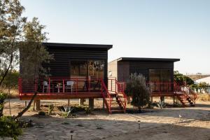 BonitoVillas Quijote Valle de Guadalupe的旁边是一座红栏杆的小房子